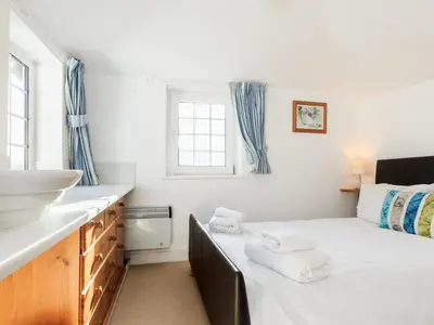 a small bedroom with a bed and a sink at Manor House in Crantock