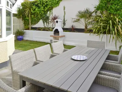 a wooden table and chairs on a patio at North Shore in Crantock
