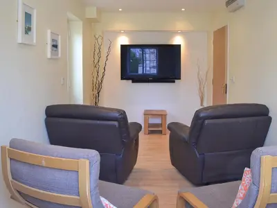 a waiting room with two chairs and a flat screen tv at North Shore in Crantock