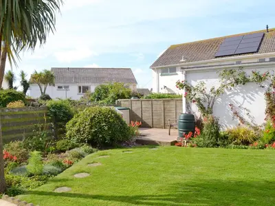 a garden with a house with solar panels on it at Sweet Briar in Newquay