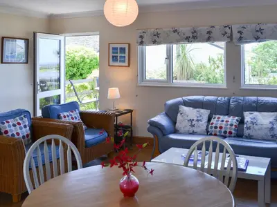a living room with a couch and a table and chairs at Treyarnon in St Merryn
