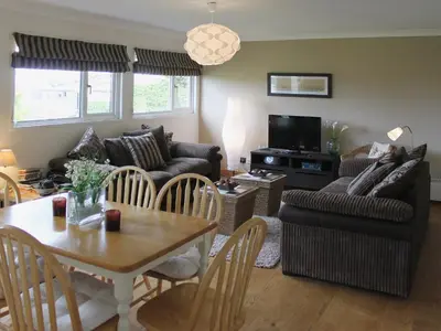 a living room with a couch and a table at Fistral in St Merryn