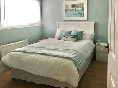 a bedroom with a bed with a white bedspread at Fistral in St Merryn