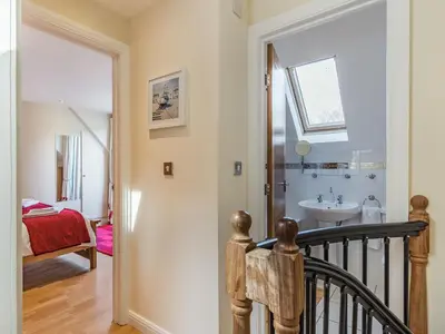 a staircase leading to a bathroom with a sink at Creekside in Little Petherick
