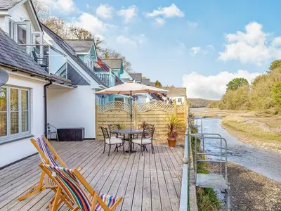 a wooden deck with a table and chairs at Creekside in Little Petherick