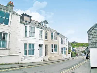 a street with white houses and people walking down the street at Sandpipers in Padstow