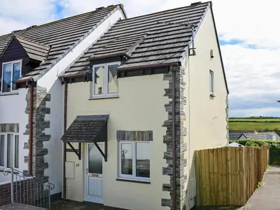 a white house with a black roof at The Yellow House in Padstow