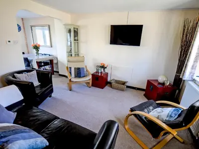 a living room with a couch and a tv at The Yellow House in Padstow