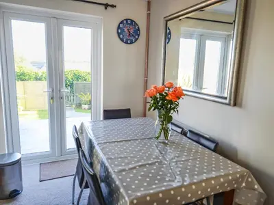 a table with a vase of orange flowers on it at The Yellow House in Padstow