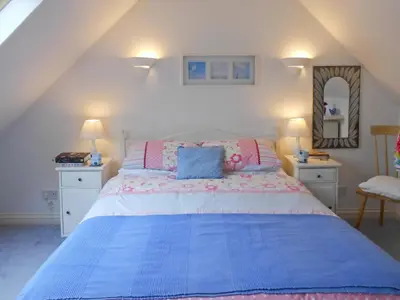 a bedroom with a bed with a blue comforter at Bellagio in Padstow