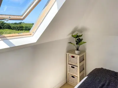 a bedroom with a window and a plant on a shelf at Bellagio in Padstow