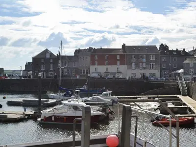 a group of boats docked in a harbor with buildings at 7 Quarrymans Cottage in Wadebridge