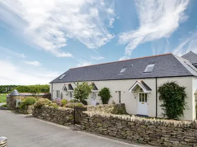 a white house with a stone wall at Sea Shells in Padstow