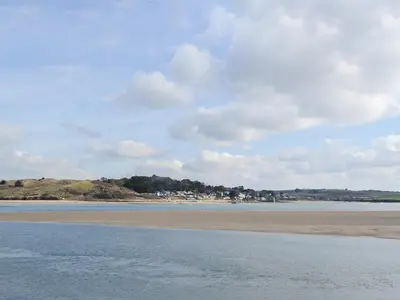 a beach with a body of water and a cloudy sky at Nan-Tis in St. Issey
