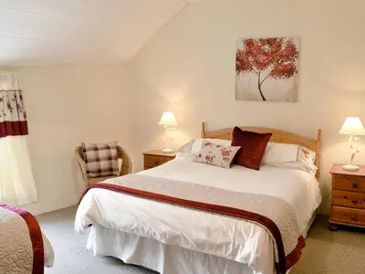 a bedroom with a bed and two lamps and a chair at Nan-Tis in St. Issey