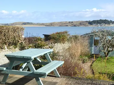 a picnic table sitting next to a body of water at Spring Tides in Padstow
