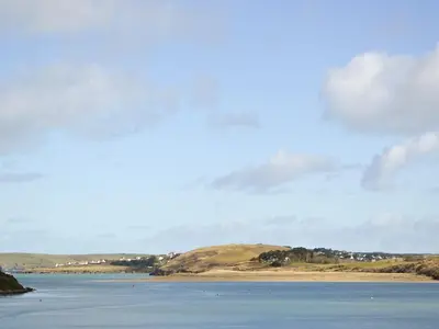 a large body of water with mountains in the background at Spring Tides in Padstow