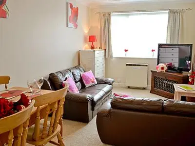 a living room with a couch and a table at Blue Waves in Perranporth