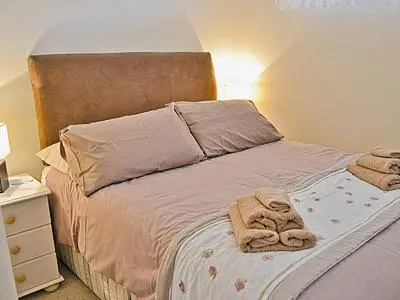 a bedroom with a bed with two towels on it at Blue Waves in Perranporth