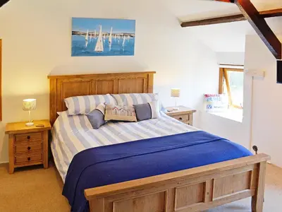 a bedroom with a bed with a blue comforter at Dover Row Cottage in Zelah