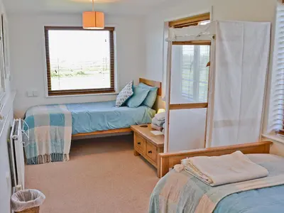 a bedroom with two beds and a window at Dover Row Cottage in Zelah