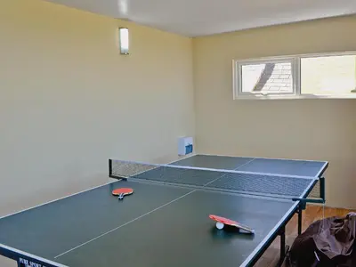 a ping pong table in a room with a tennis court at Dover Row Cottage in Zelah