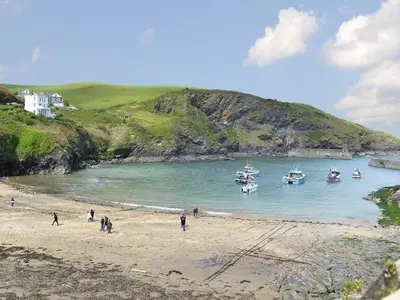 people on a beach with boats in the water at Roosters Perch in Saint Kew