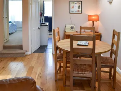 a kitchen and dining room with a table and chairs at Cobblers Cottage in Port Isaac