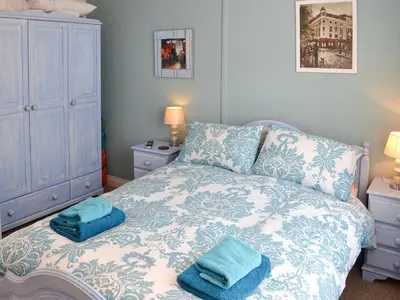 a bedroom with a bed with two towels on it at Cobblers Cottage in Port Isaac
