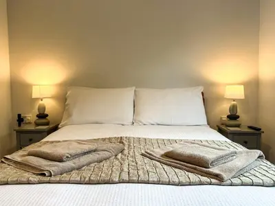 a bedroom with a bed with two lamps on both sides at Lower Moon in Port Isaac