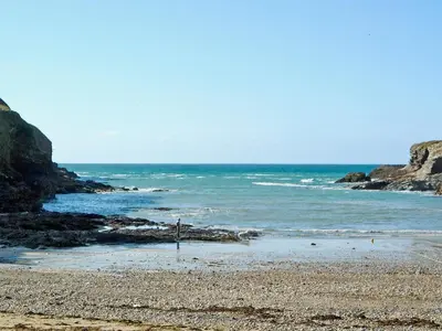 a beach with the ocean and rocks on it at The Lookout in Port Isaac