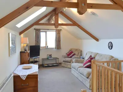 a living room with a couch and a tv at Saundry's Barn in Port Isaac
