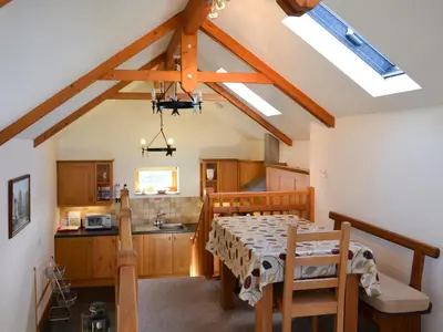 a kitchen with a table and chairs in a room at Saundry's Barn in Port Isaac