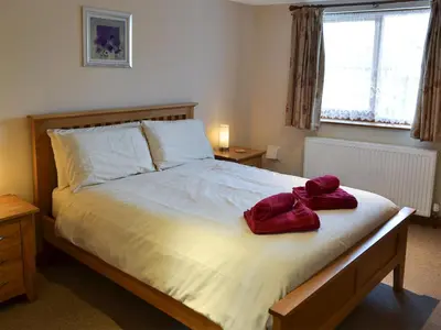 a bedroom with a bed with two red towels on it at Saundry's Barn in Port Isaac