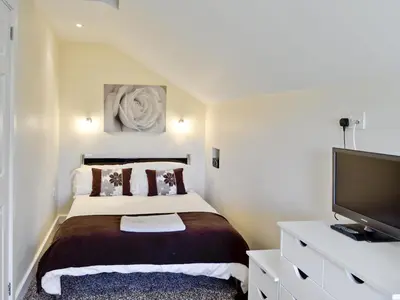 a bedroom with a bed and a flat screen tv at Owls Park in Saint Endellion
