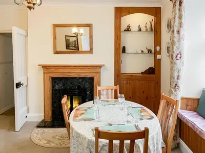 a dining room with a table and a fireplace at Atlantic House - 27665 in Port Isaac
