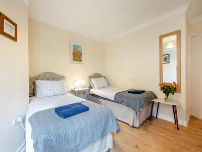 a bedroom with two beds and a mirror at Pennard in Tuckingmill