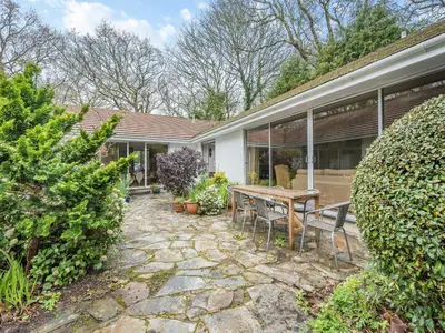 a patio with a table and chairs in front of a house at Pennard in Tuckingmill