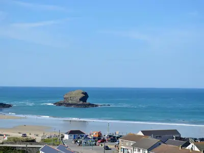 a view of a beach with a rock in the ocean at 2 The Courtyard in Portreath