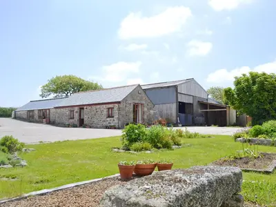 an old stone barn with plants in a yard at Ash Tree Cottage in Carnbrea