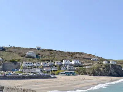 a group of houses on a hill next to the beach at Ash Tree Cottage in Carnbrea