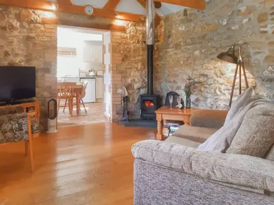 a living room with a couch and a fireplace at The Old Dairy in Mount Hawke