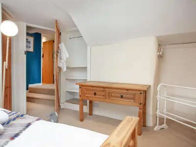 a bedroom with a bed and a wooden desk at The Farm House in Porkellis