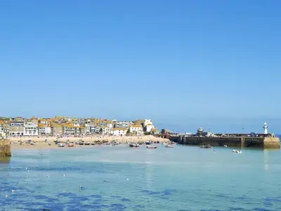 a beach with a bunch of boats in the water at Maple Barn in Porthtowan