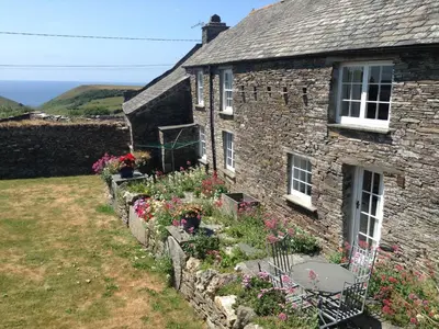 an old stone house with flowers in front of it at Culvada in Treknow