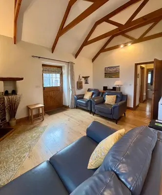 a living room with a blue couch and chairs at Rose Cottage, Tregolls Farm in Saint Wenn
