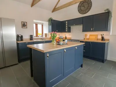 a kitchen with blue cabinets and a counter top at Pol View in Helston