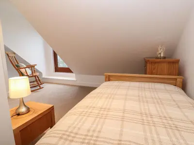 a bedroom with a bed and a lamp at Pol View in Helston