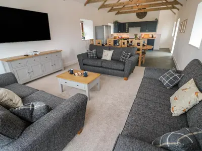 a living room with two couches and a tv at Pol View in Helston