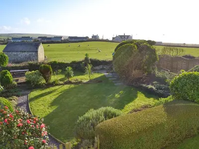 an aerial view of a garden with a field and animals at Tregatta Terrace in Tintagel